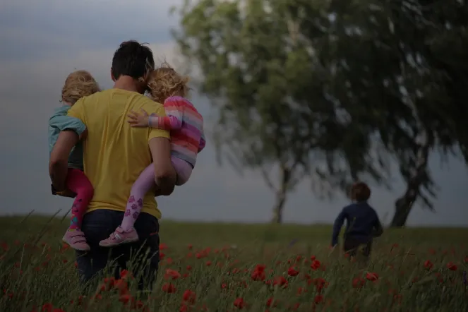 Kinder und Erwachsener auf Blumenwiese